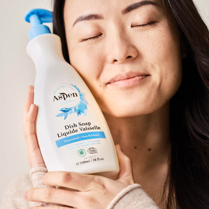 Lady is holding AspenClean Dish Soap Unscented.
