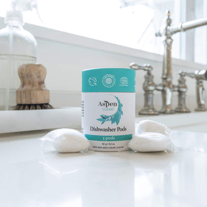 AspenClean dishwasher pods in travel size on a kitchen counter with pods around it.
