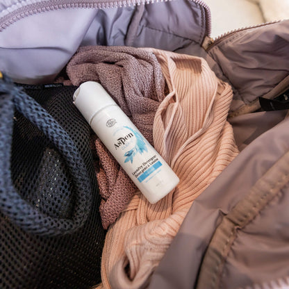 AspenClean laundry detergent travel size inside a bag with clothes