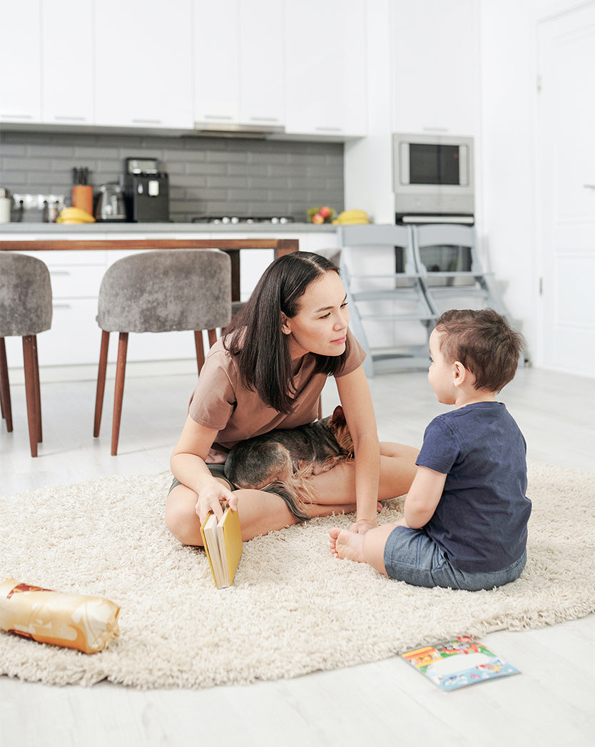 Mom and a son relaxing on a carpet freshly vacuumed by an AspenClean house cleaning service, happy to write a review
