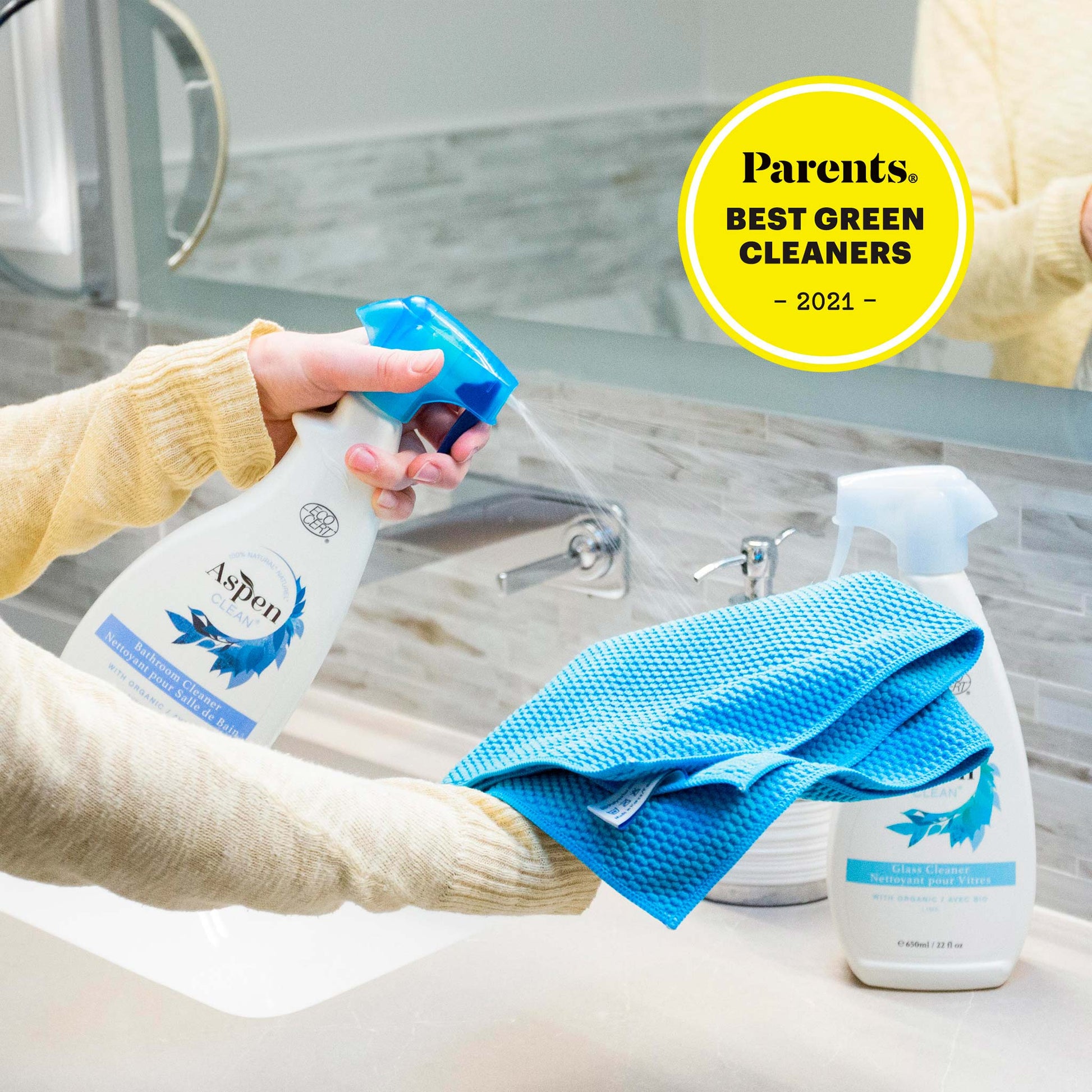 A woman using AspenClean Best Bathroom Cleaner to clean a bathroom countertop