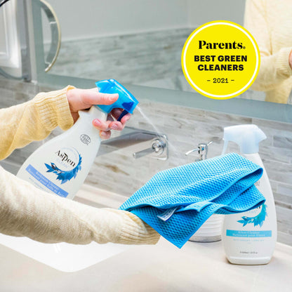 A woman using AspenClean Best Bathroom Cleaner to clean a bathroom countertop